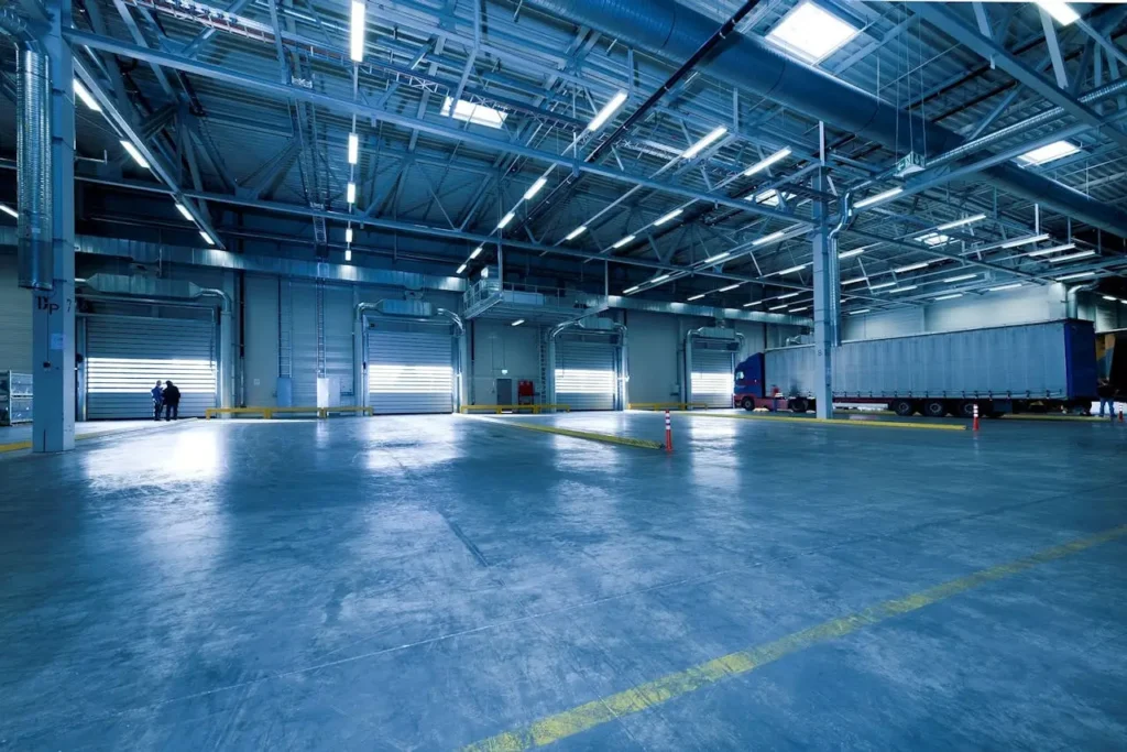 Large warehouse interior with docked truck, ideal for logistics and warehousing.